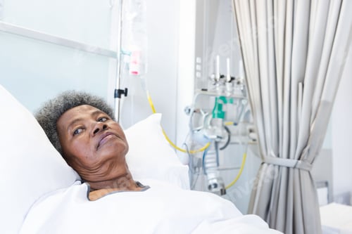 Preview: Senior African American woman resting in hospital room, with IV and ventilator tubing, copy space