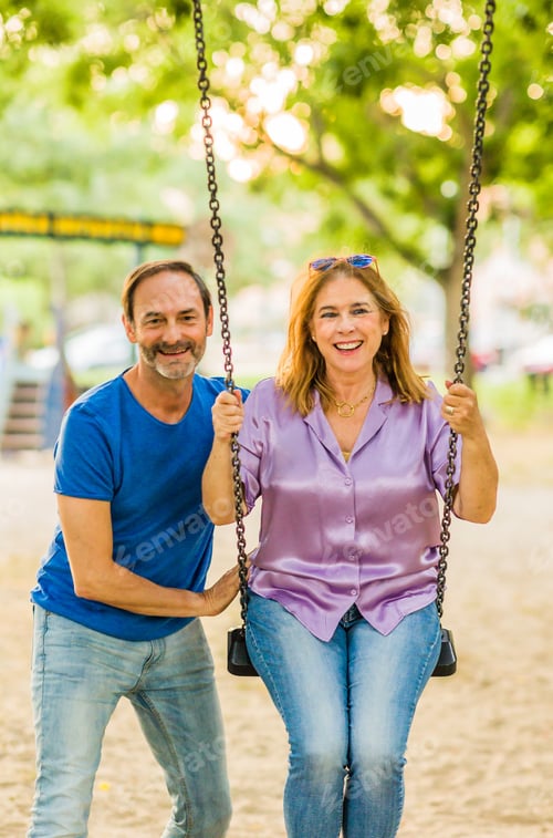 Preview: 50-59 years senior happiness relationship. Hispanic family enjoy life couple with a swing in a park