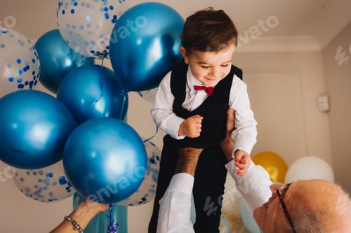 Preview: Grandfather holds his grandson above his head on his birthday