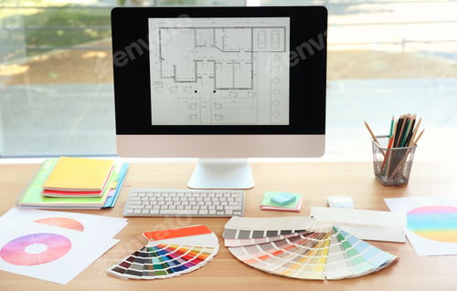 Preview: Designer's workplace with computer and paint color palette samples on table