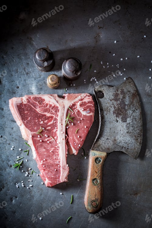 Preview: Raw t-bone steak on old metal table