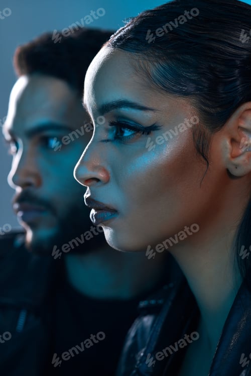 Preview: Conceptual shot of a stylish young man and woman posing in studio against a blue background