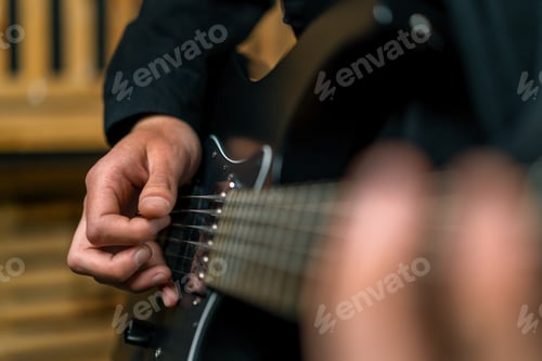 Preview: rock performer with electric guitar in recording studio recording playing own track