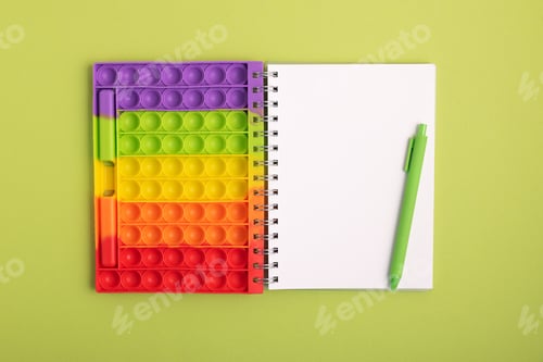 Preview: Mockup from notebook with school stationery supplies on green background. Top view. Copy space