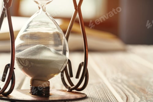 Preview: Closed up of sandglass or hourglass on background of book