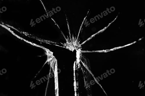 Preview: Close up of broken, cracked pane of glass with hole, on black background