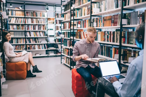 Preview: Multiracial students sitting near bookcases