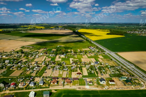 Preview: Top view of the yellow rapeseed field and the village. A sown field of rapeseed in Belarus.The