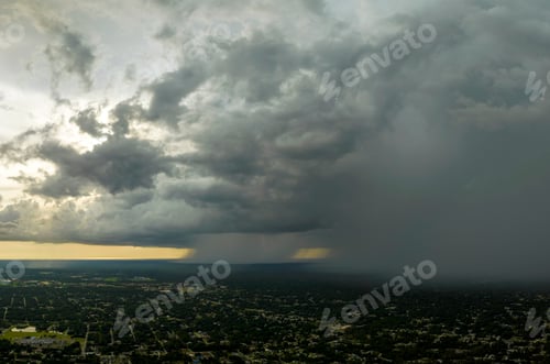 Preview: Dark stormy clouds forming on gloomy sky during heavy rainfall season over suburban town area