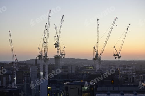 Preview: Cranes surrounded by buildings during the sunset in the evening in Edinburgh in Scotland