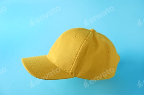 Preview: Yellow baseball hat in air on light blue background