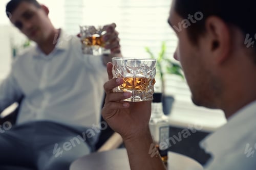 Preview: Young men drinking whiskey together at home