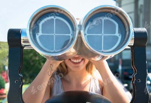Preview: Young woman looking through coin operated binoculars at the Monte dei Cappuccini, Turin, Italy