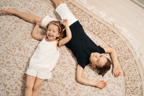 Preview: Happy kids lying on the carpet