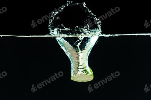 Preview: Fresh lime dropped into water with splash
