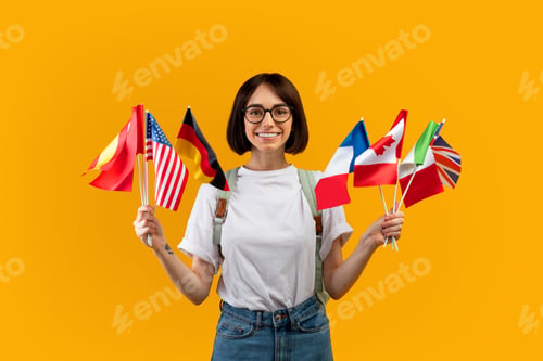 Aperçu: Happy lady showing bunch of diverse flags cheerfully smiling at camera over yellow studio background