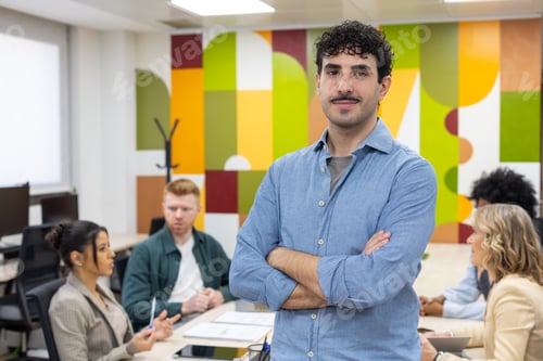 Preview: Confident man leading business meeting in modern office