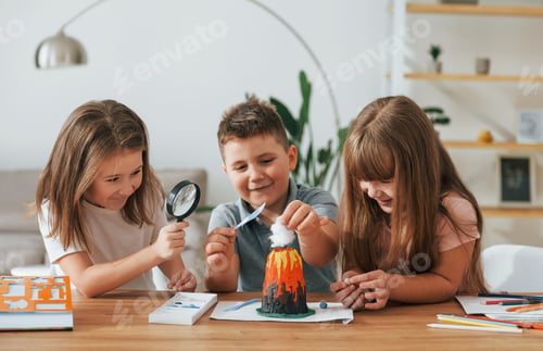 Preview: Working on the volcano project. Kids having fun in the domestic room at daytime together
