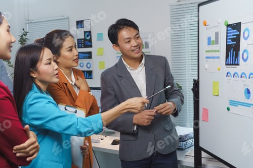 Preview: Group of diverse asian businesspeople discussing charts and statistics during a meeting in a modern
