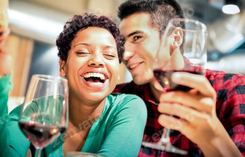 Preview: Happy multiracial couple of lover drinking red wine at fashion restaurant