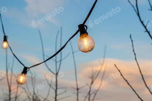 Preview: String lights against sunset sky