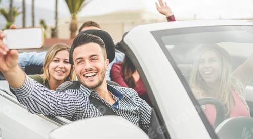 Preview: Happy friends making a selfie video streaming in convertible car on summer vacation