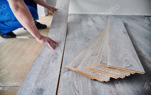 Preview: Male hands installing laminate flooring in apartment.
