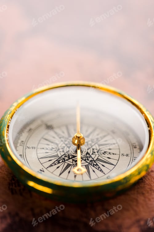 Preview: close up of vintage compass with golden arrow