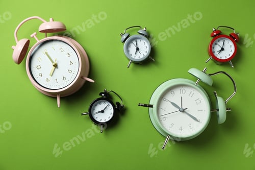 Preview: Different multicolor alarm clocks on green background