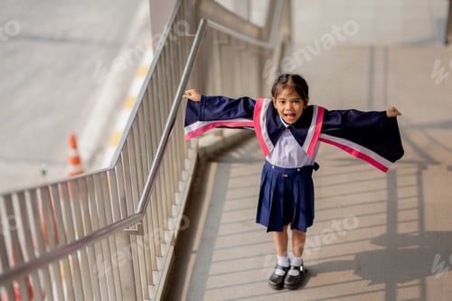Preview: Happy Asian girls in graduation gowns on their graduation day at school.Graduation concept