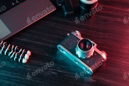 Preview: Old film camera and laptop on table. Hipster working area