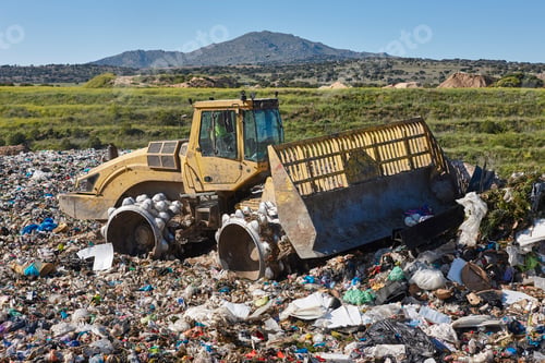 Preview: Heavy machinery shredding garbage in an open air landfill. Pollution