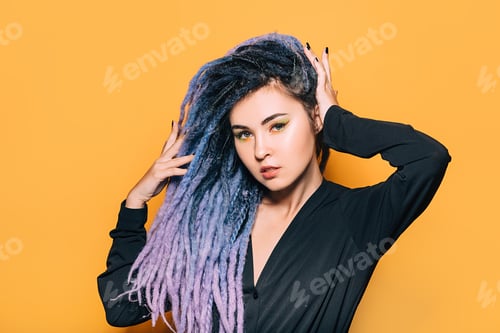Preview: Portrait of pretty woman with purple dreadlocks on orange background