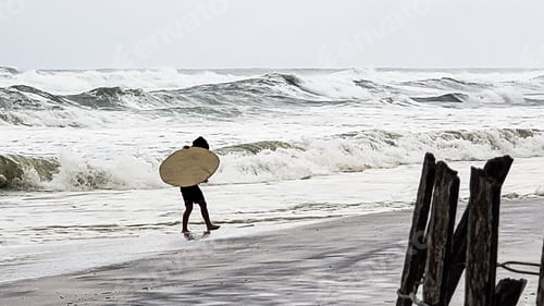 Preview: Gen z kids being kids on seashore after a weather event ready to surf the ocean waves.
