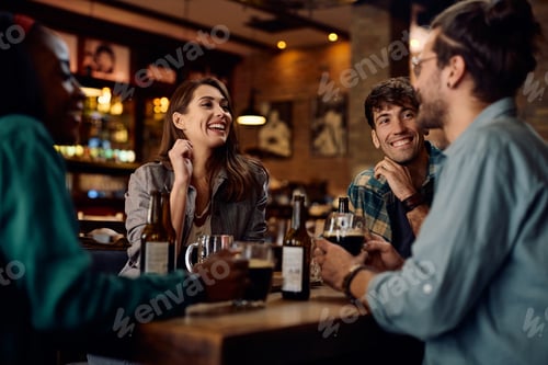 Preview: Group of happy friends enjoying in beer and conversation in a pub.