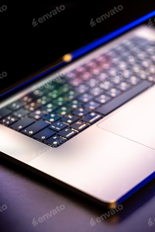 Preview: A laptop computer with a half-open screen on a dark background.