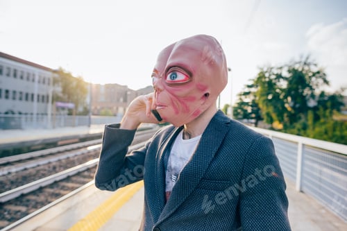 Preview: Young bearded man talking smartphone wearing mask