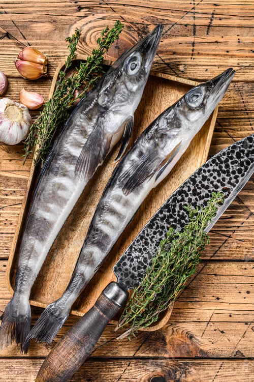 Preview: Raw mackerel icefish in a wooden tray. Wooden background. Top view