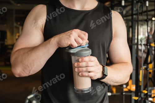Preview: Bodybuilder during strength training with protein shaker