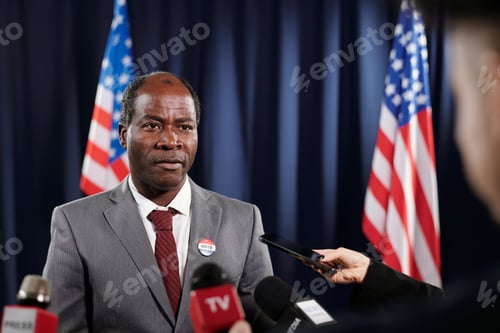 Preview: African American male delegate in formalwear giving interview to journalists
