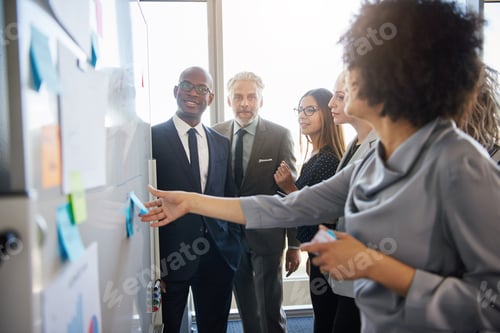 Preview: Group of mixed business people having a meeting using a white board