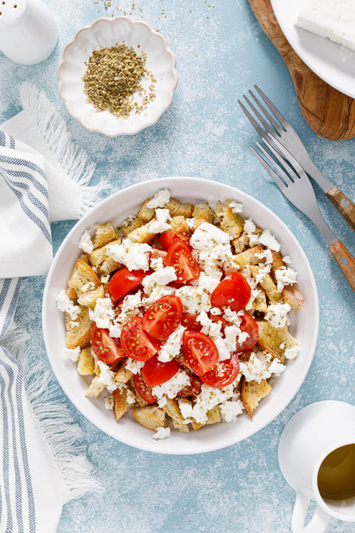 Preview: Dakos or koukouvagia salad. Classic recipe Cretan barley rusk salad with fresh tomato, mizithra