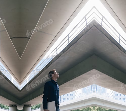Aperçu: Businessman standing at underpass holding laptop, composite