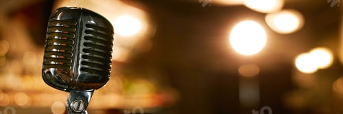 Preview: Header Image of Microphone against Blurred Lights in Bar