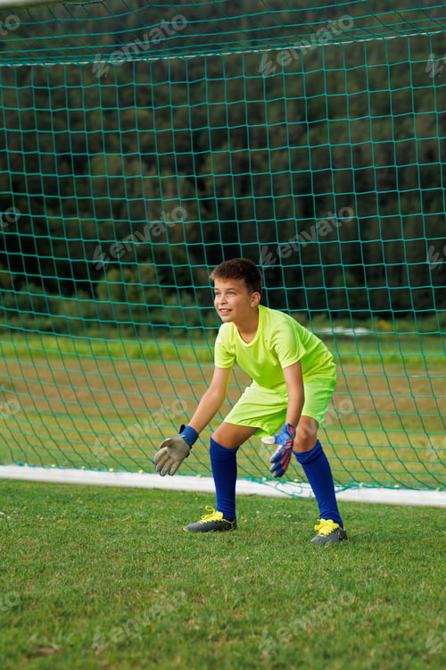 Vista previa: A young footballer in a green uniform on goal