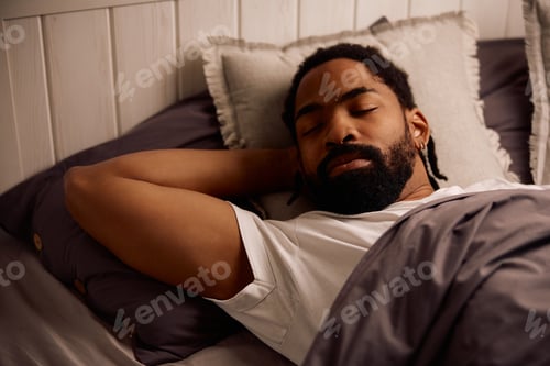 Preview: Relaxed black man sleeping in bedroom.