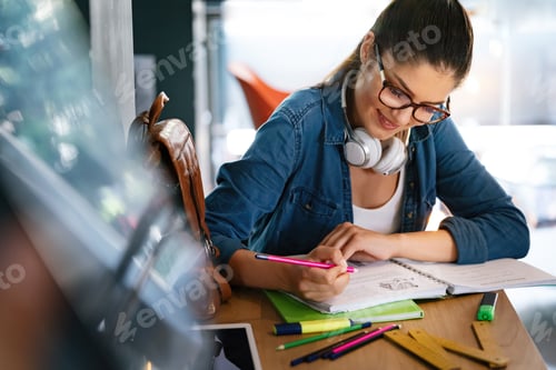 Preview: Lovely student girl making her homework, studying, preparing for exam