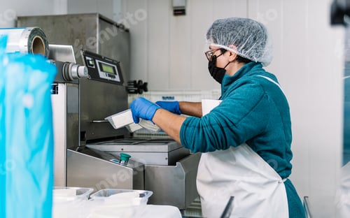 Preview: Worker packaging food products in a hygiene controlled environment