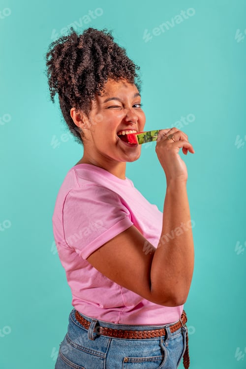 Preview: Woman eating a slice of watermelon in the form of ice cream on a turquoise background