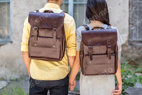Preview: Back of woman and man with brown leather backpack